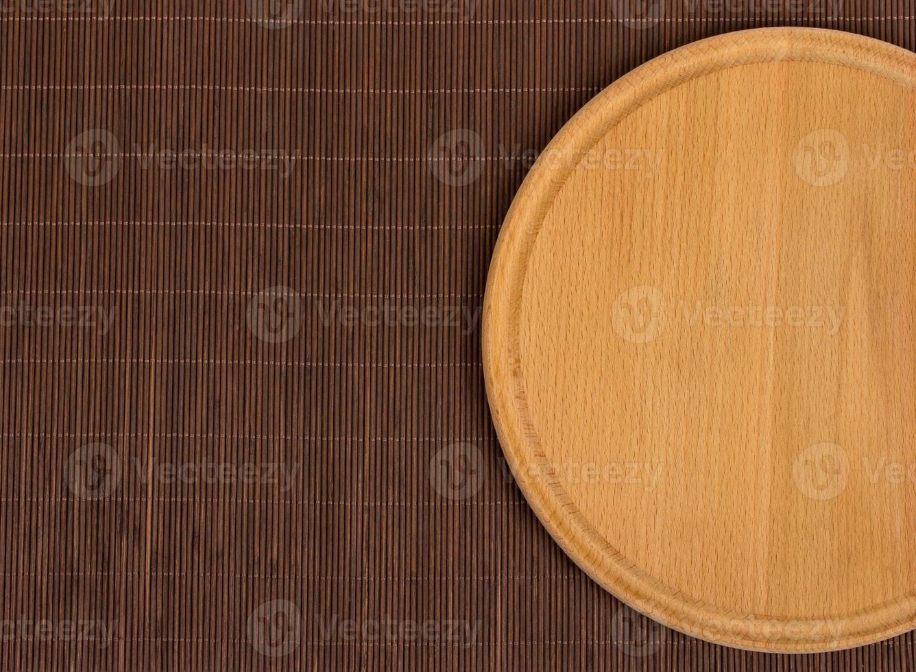 Empty round wooden board with tablecloth. photo