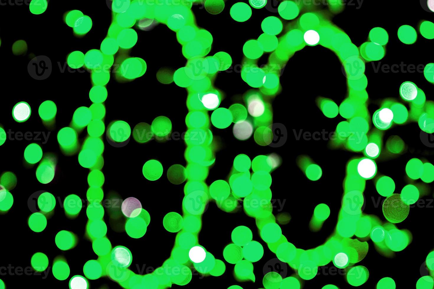 Unfocused abstract colourful bokeh black background. defocused and blurred many round green light photo