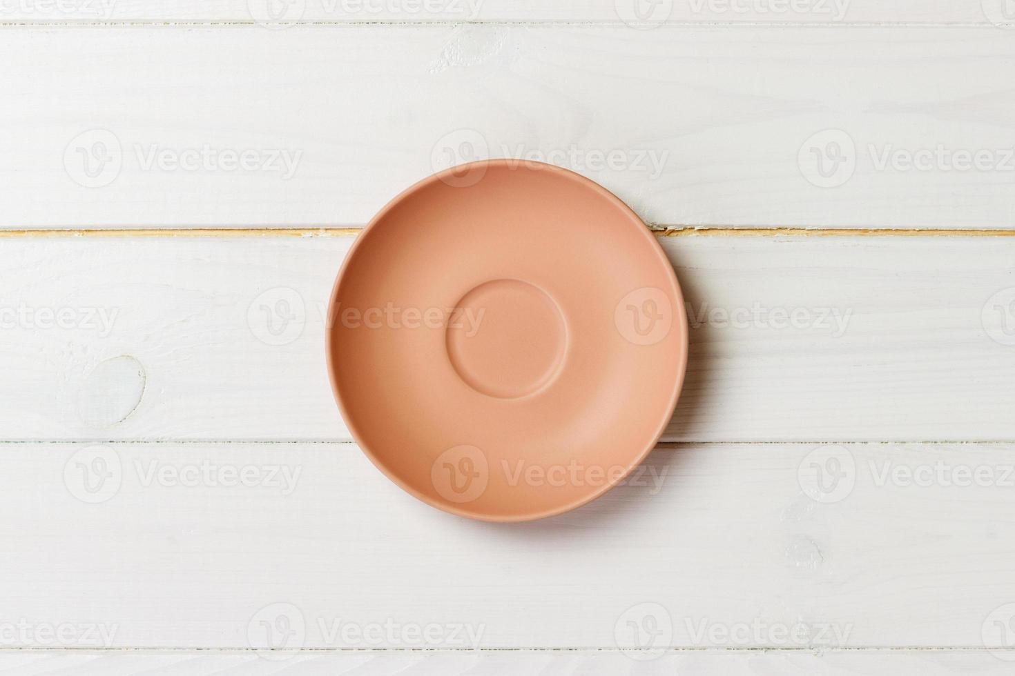 empty orange matte plate on wooden background photo