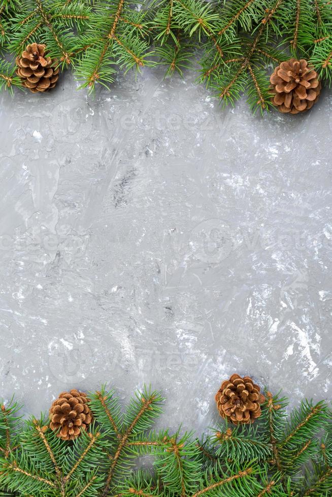 Christmas gray cement wooden background with fir tree frame and cones copy space. top view empty space for your design photo