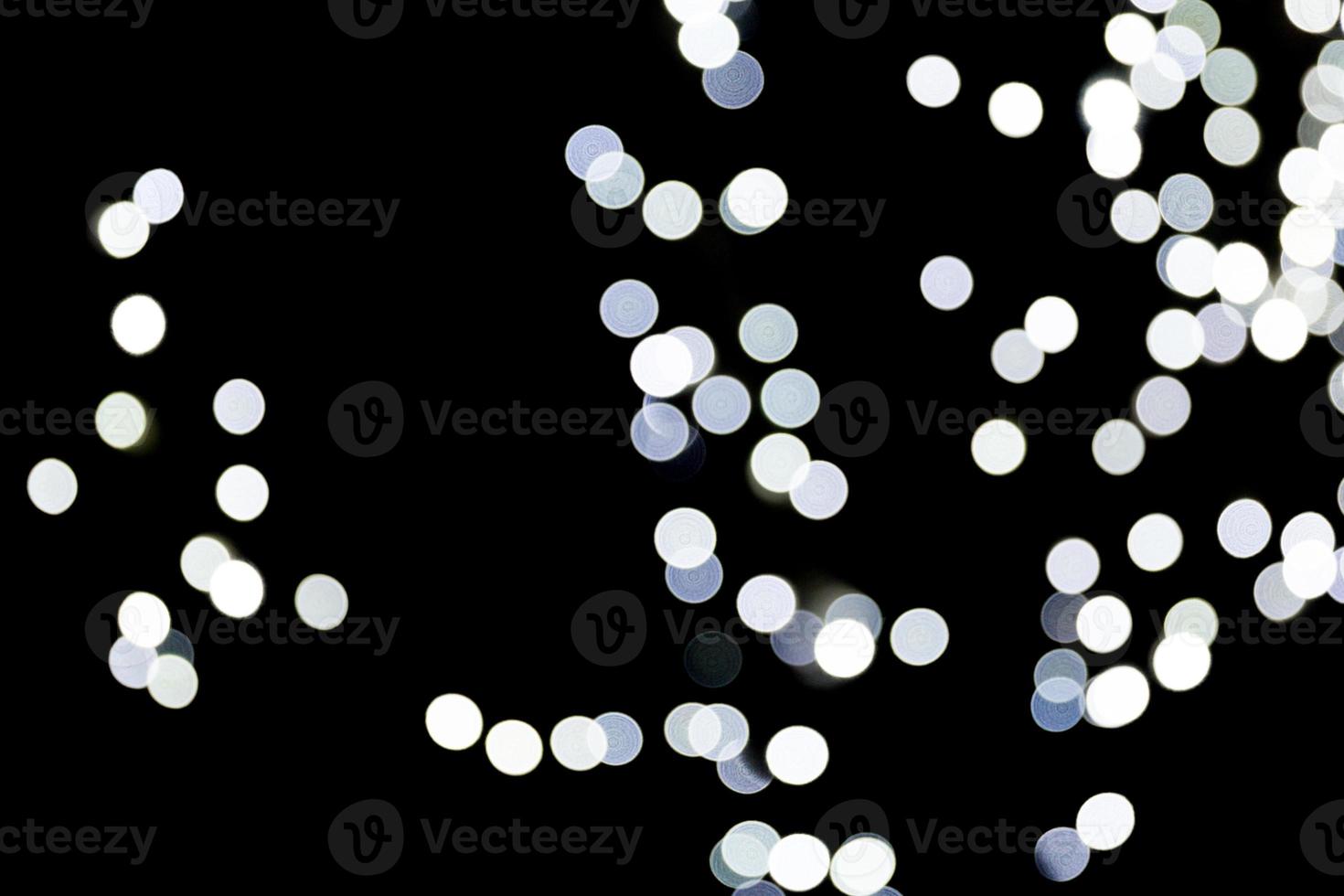 Unfocused abstract white bokeh on black background. defocused and blurred many round light photo