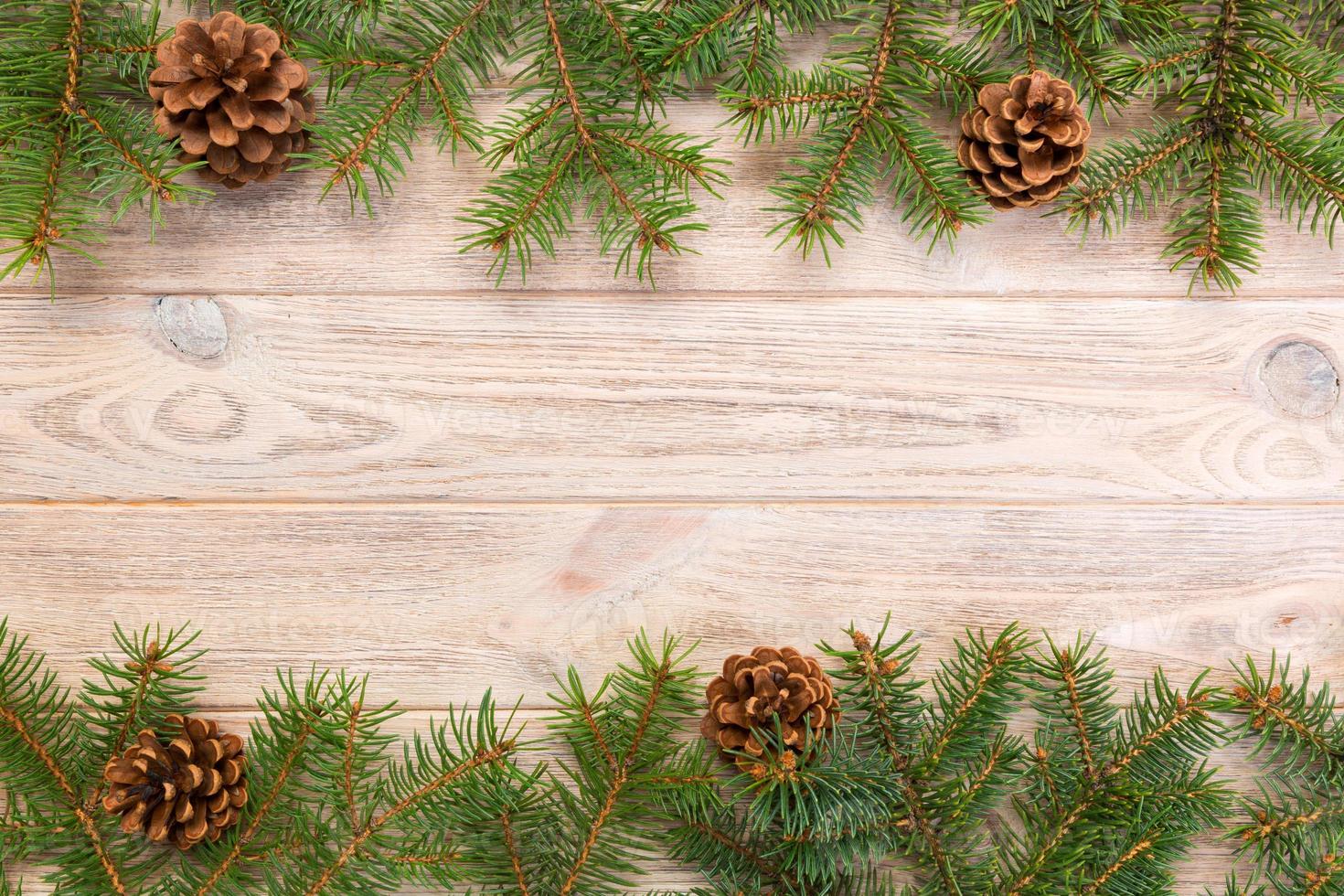 Christmas gray wooden background with fir tree frame and cones copy space. top view empty space for your design photo