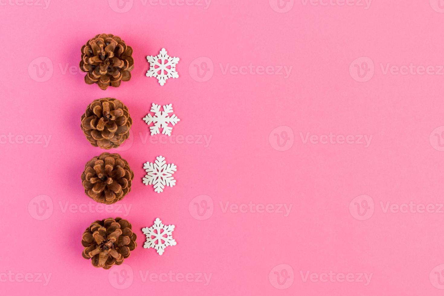 Top view of holiday composition made of pine cones and white snowflakes on colorful background. Winter time and Christmas concept with copy space photo