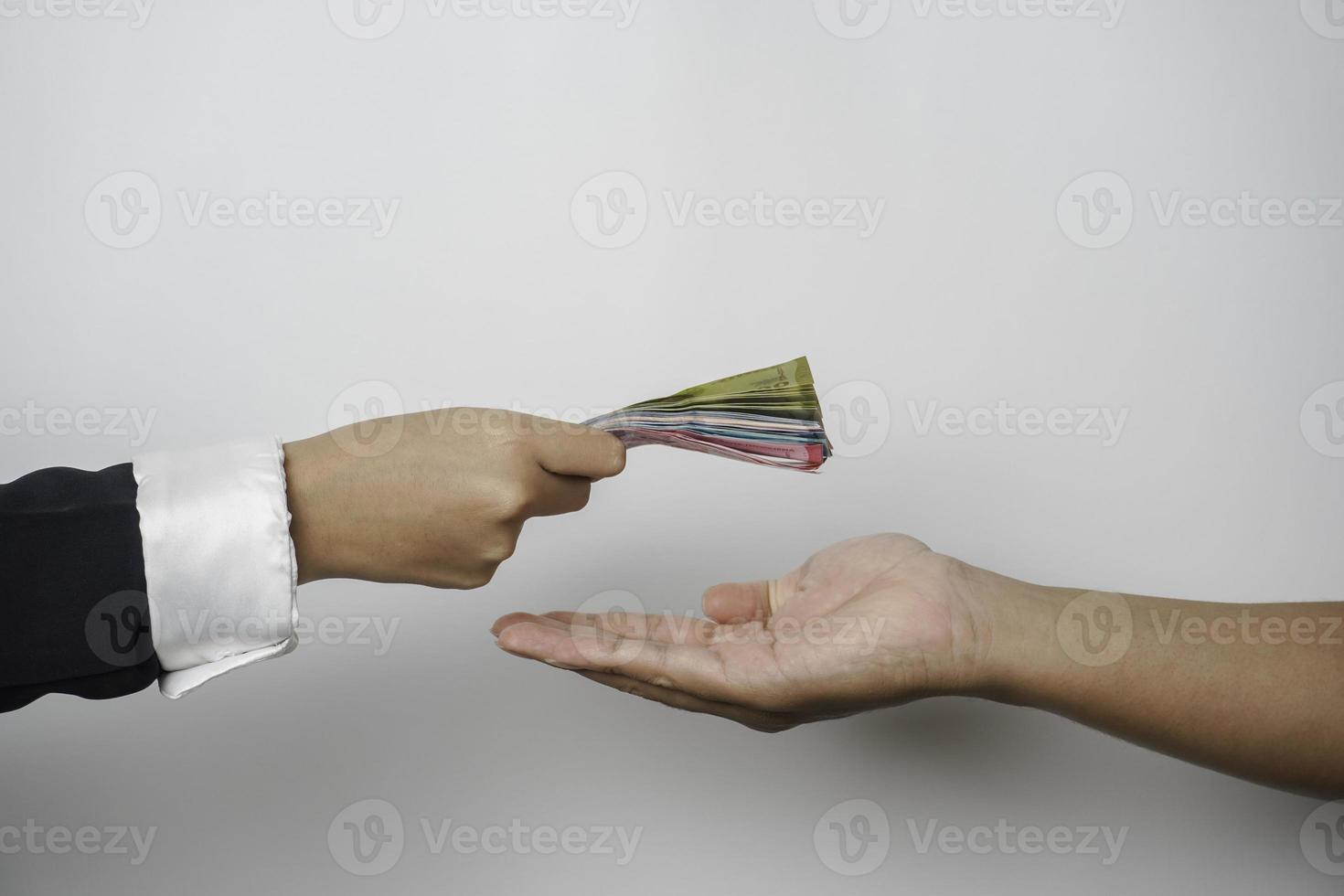 A portrait of businessman giving money in Indonesian Rupiah for business deal or payment or charity photo