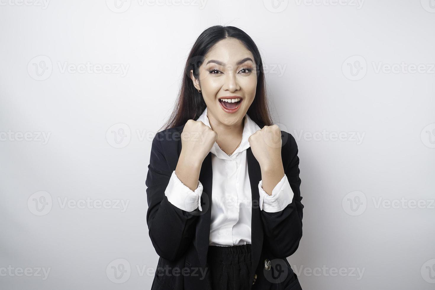 A young Asian businesswoman with a happy successful expression wearing black suit isolated by white background photo