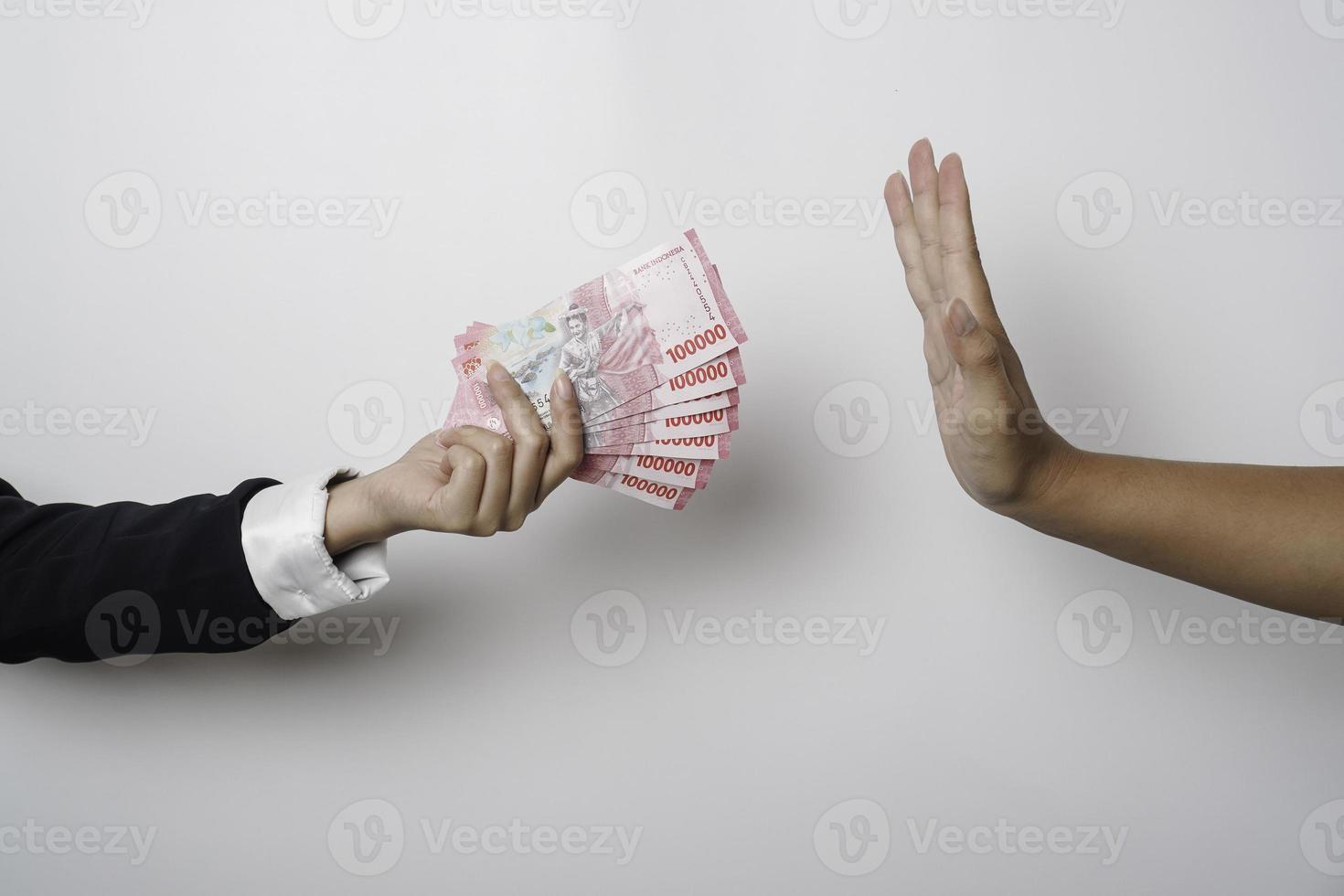 A portrait of businessman refusing money, Indonesian rupiah bills - anti-bribery and corruption concepts photo