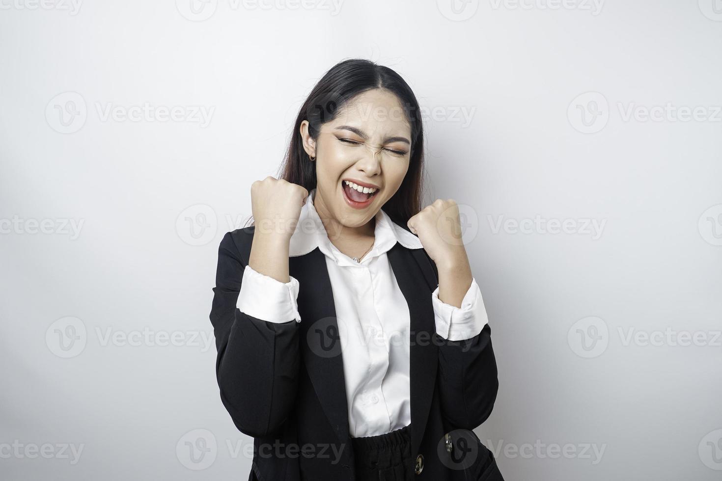 A young Asian businesswoman with a happy successful expression wearing black suit isolated by white background photo