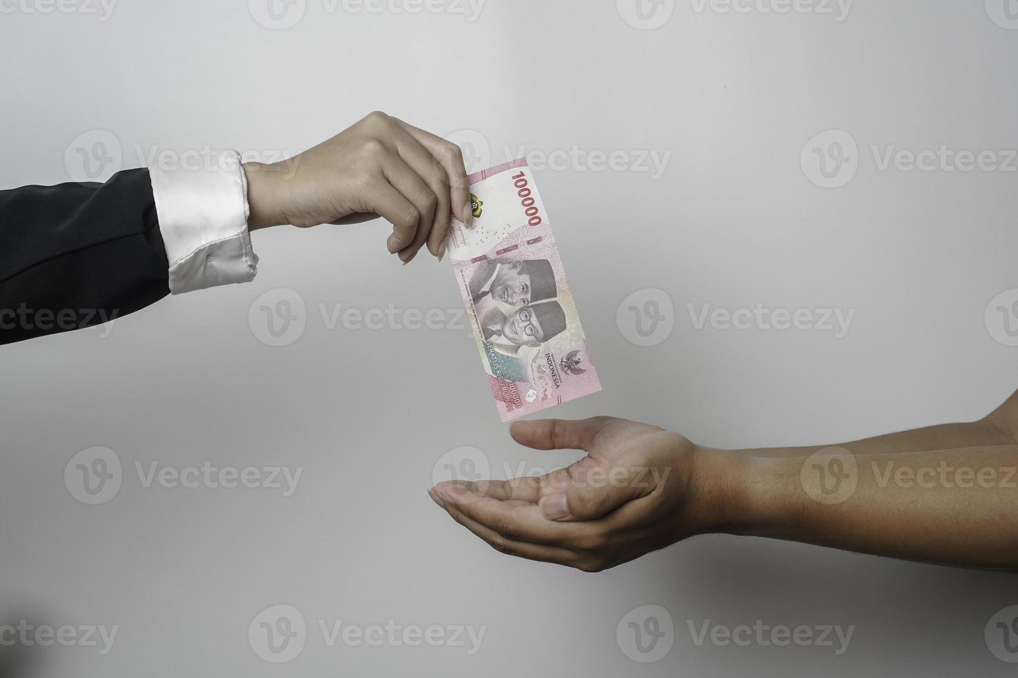 A portrait of businessman giving money in Indonesian Rupiah for business deal or payment or charity photo