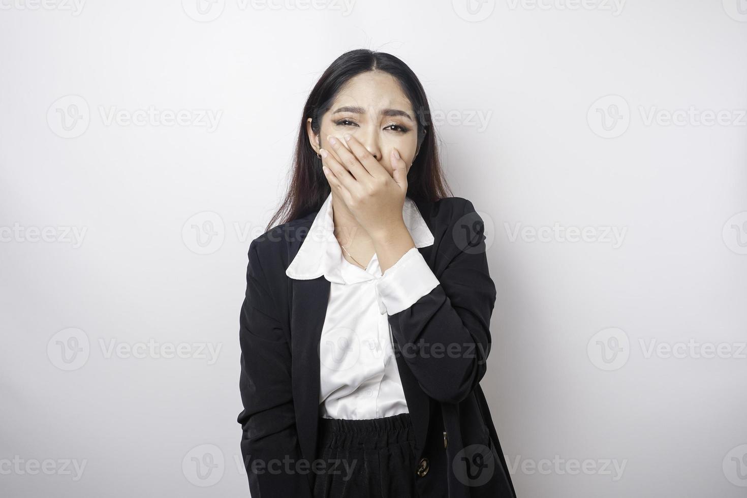 A portrait of an Asian business woman wearing a black suit isolated by white background looks depressed photo