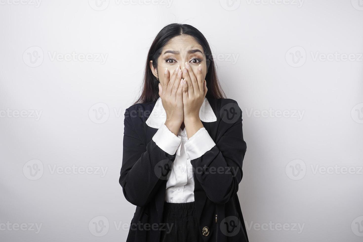 A portrait of an Asian business woman wearing a black suit isolated by white background looks depressed photo