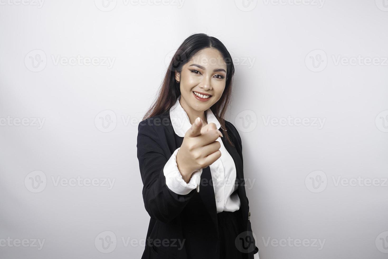 joven y hermosa mujer de negocios asiática parada sobre un fondo blanco aislado señalando con el dedo a la cámara con cara feliz. buena energia y vibras. foto