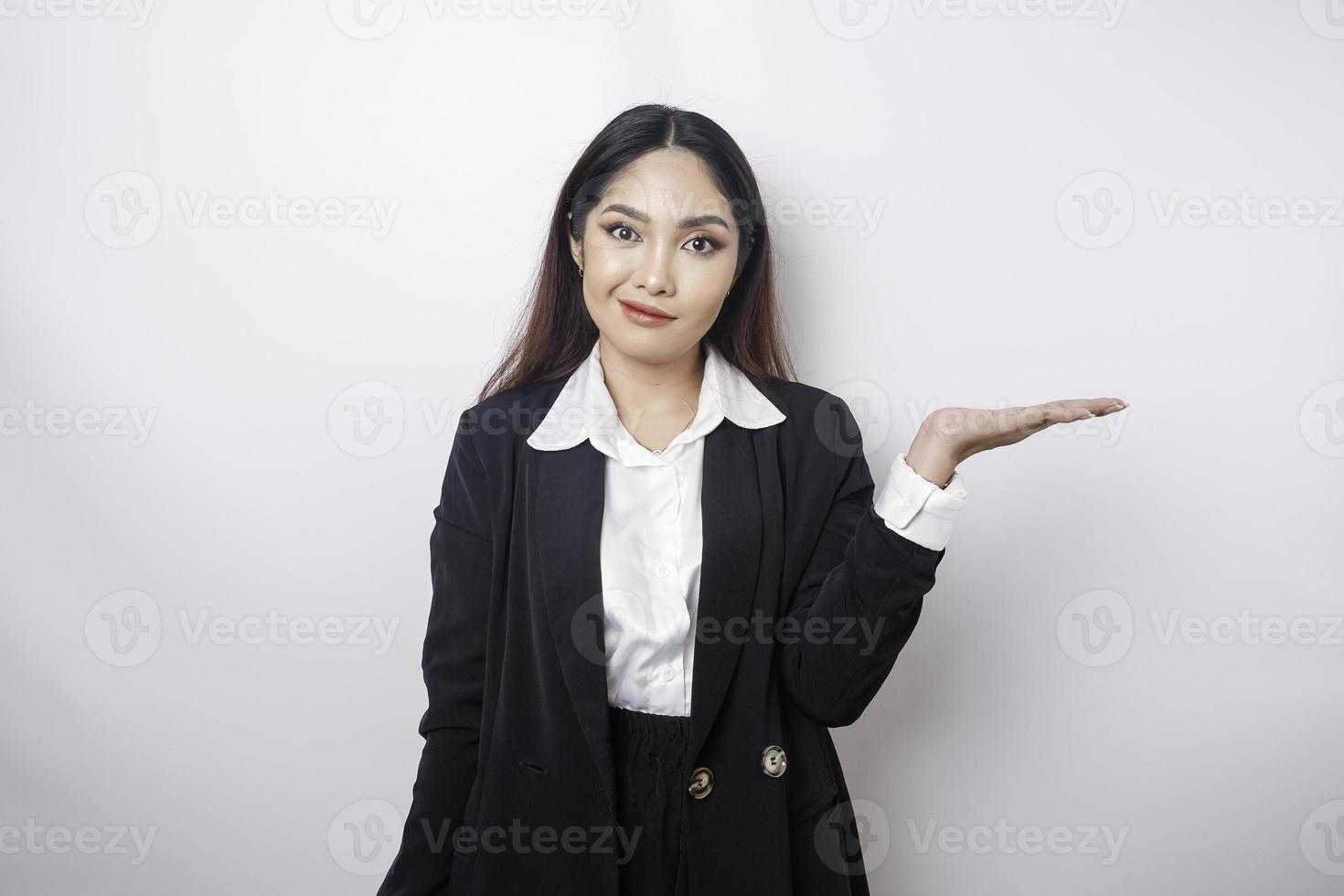 A portrait of an Asian girl boss wearing a black suit looks so confused between choices, isolated by a white background photo
