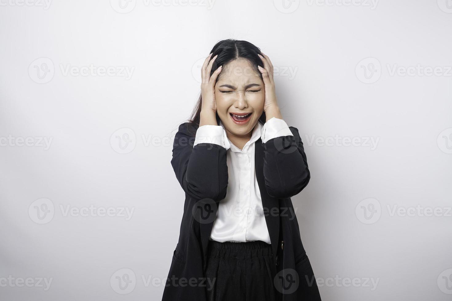 A portrait of an Asian business woman wearing a black suit isolated by white background looks depressed photo