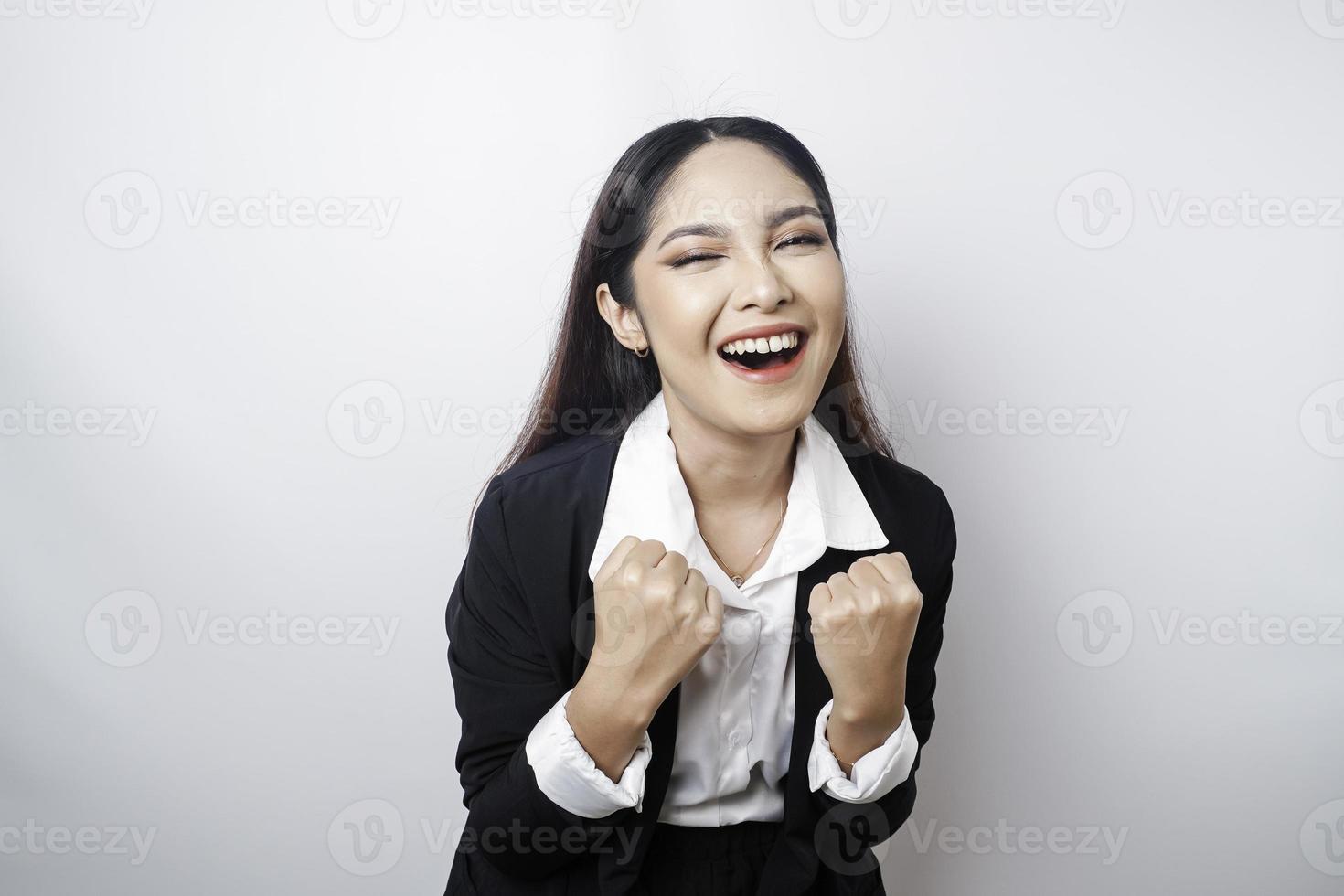 una joven mujer de negocios asiática con una expresión feliz y exitosa con traje negro aislada de fondo blanco foto