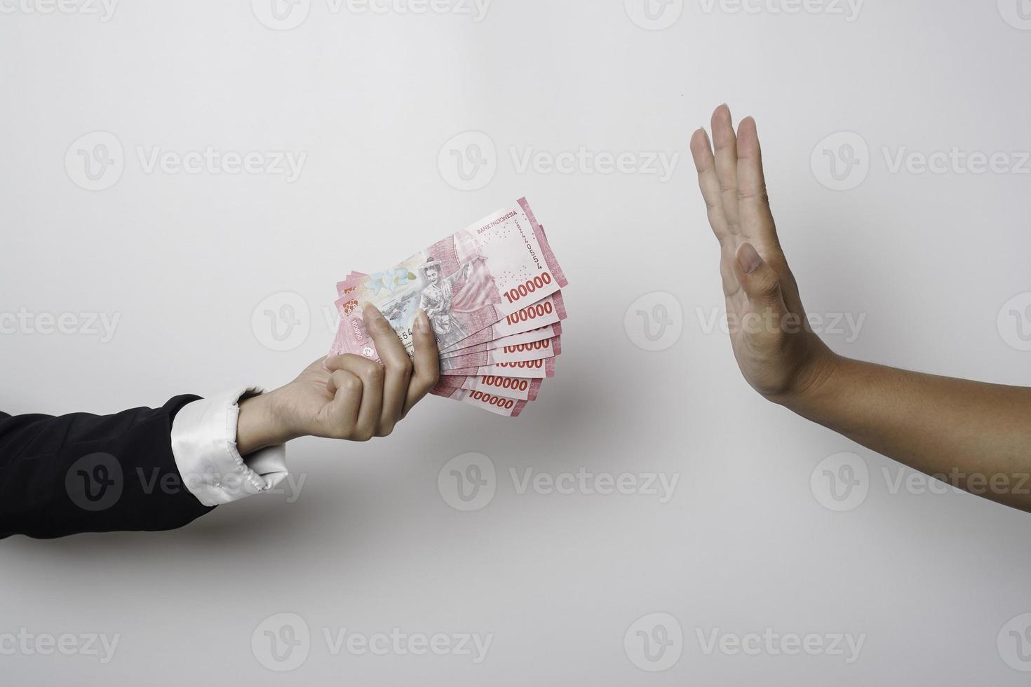 A portrait of businessman refusing money, Indonesian rupiah bills - anti-bribery and corruption concepts photo