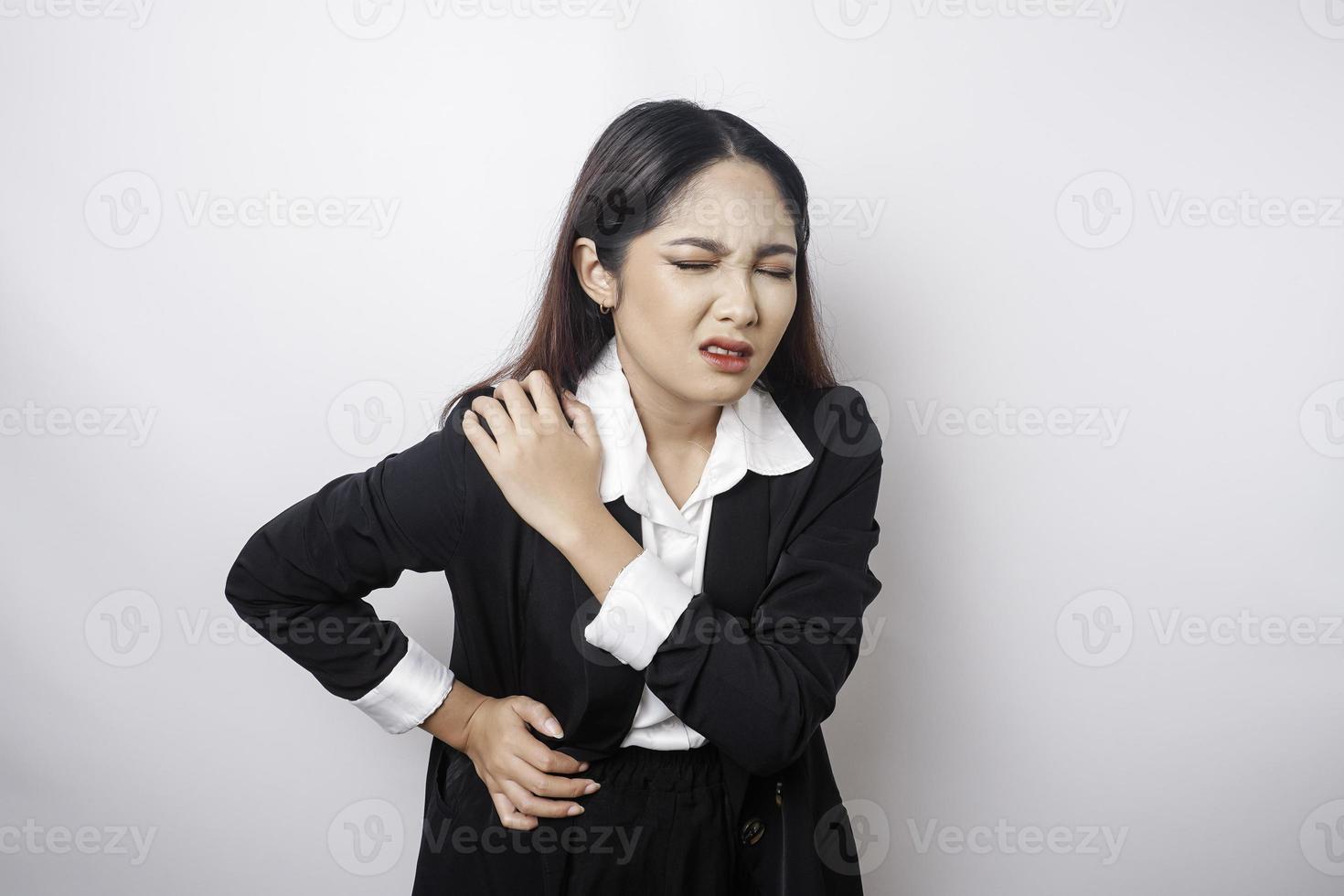 mujer de negocios joven cansada y molesta que sufre de dolor, espasmo muscular en el lugar de trabajo. fatiga, fecha límite, dolor y postura incorrecta foto