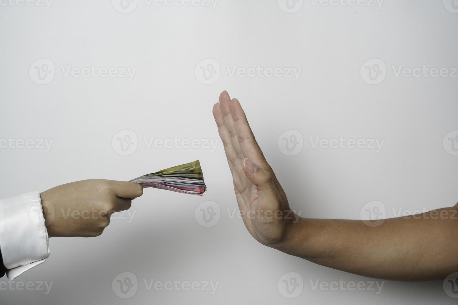 A portrait of businessman refusing money, Indonesian rupiah bills - anti-bribery and corruption concepts photo