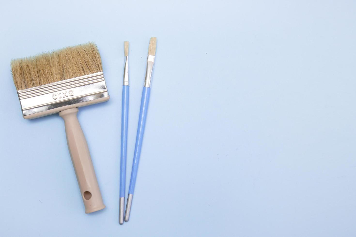 paint brush with small brushes on a light blue background with copy space photo