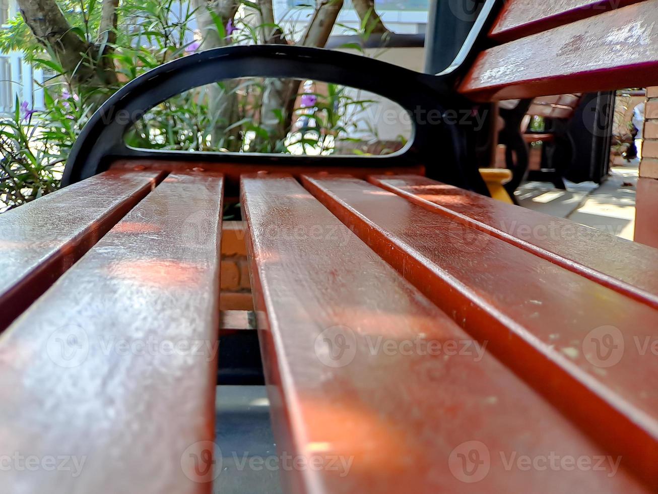 bench rest area made of black brown wood and iron, bright blue sky in the garden of the city of Madiun Indonesia. photo