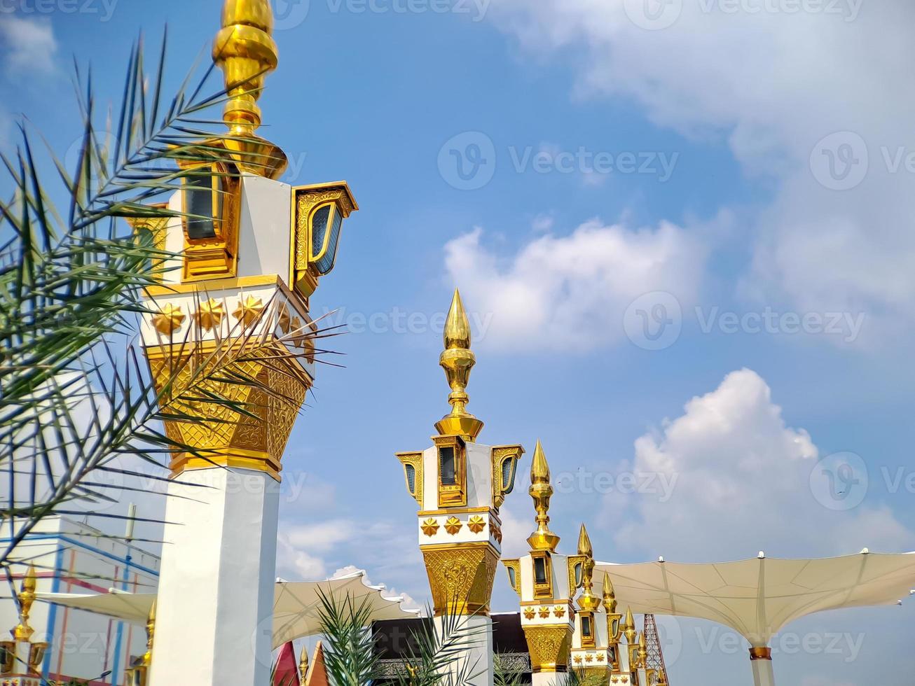 brown gold white color mosque minaret with arabic architecture in madiun indonesia park, sunny weather. photo