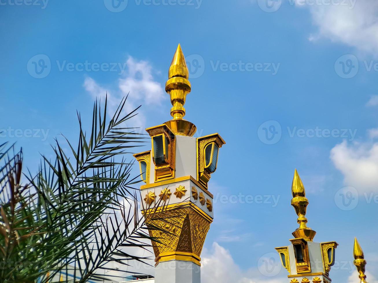 brown gold white color mosque minaret with arabic architecture in madiun indonesia park, sunny weather. photo