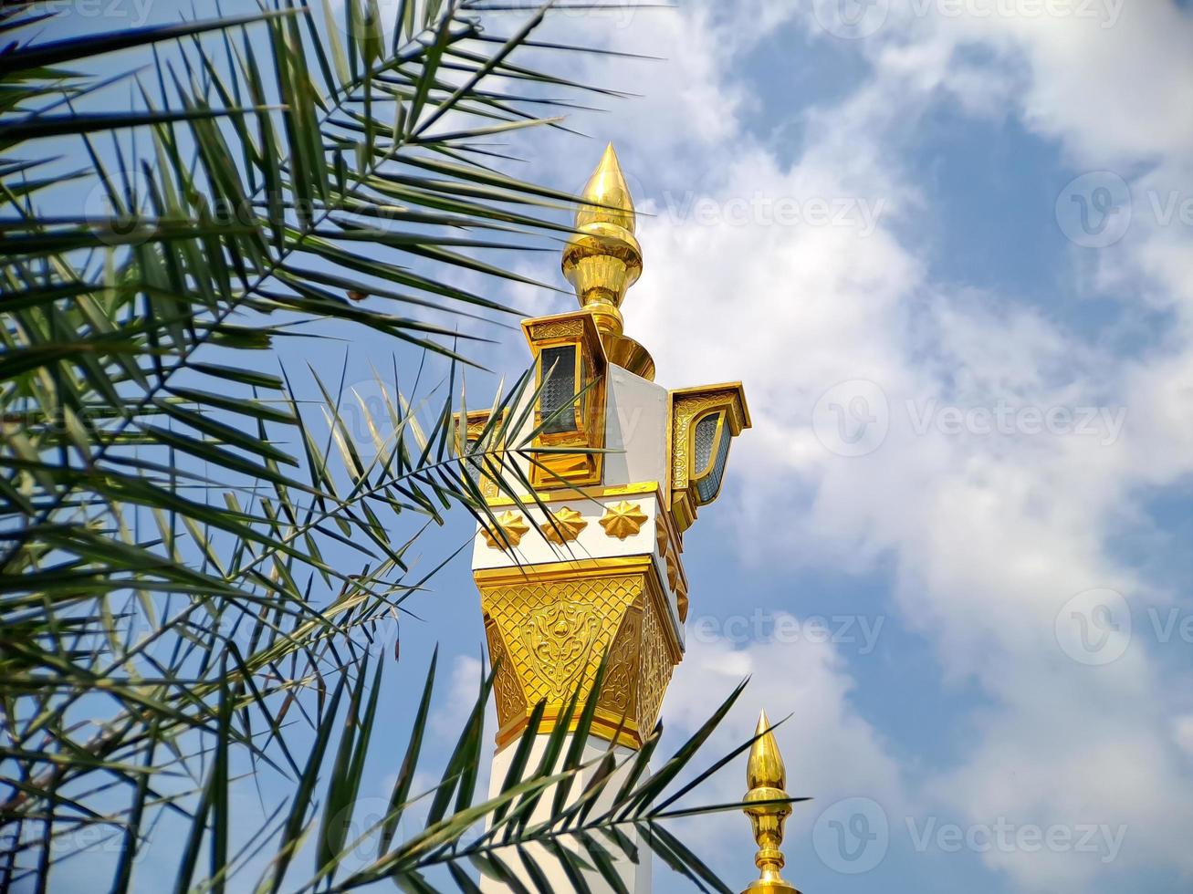 brown gold white color mosque minaret with arabic architecture in madiun indonesia park, sunny weather. photo