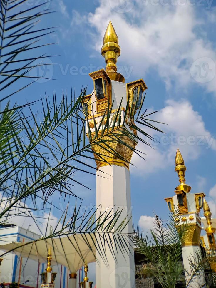 brown gold white color mosque minaret with arabic architecture in madiun indonesia park, sunny weather. photo