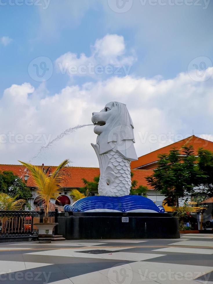 Replica of Singapore white lion statue, in the city park of Madiun Indonesia with clear blue sky. photo