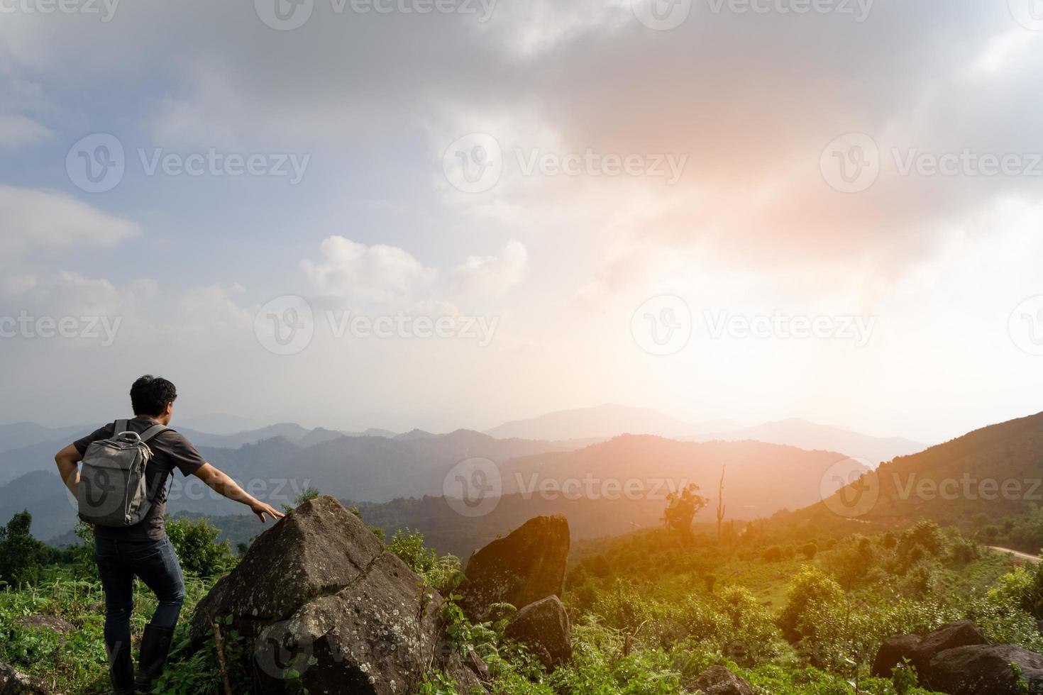 A wide shot of sian man with his backpack is travel alone and look at far a way, nature travel and environment concept, copy space for individual text photo