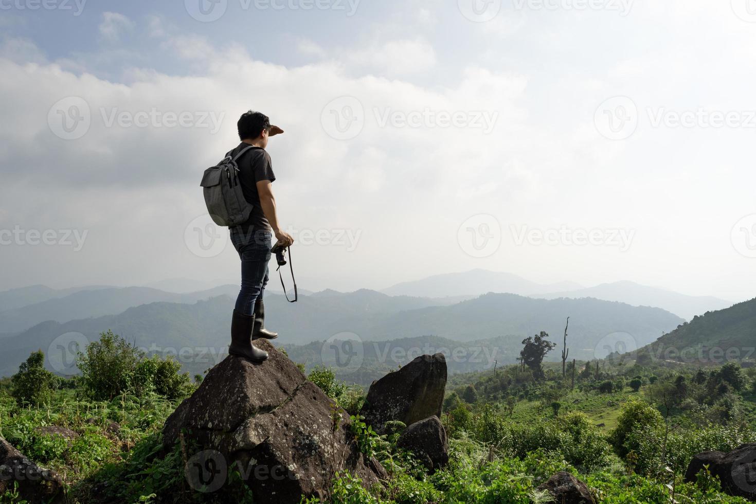 una toma amplia de un hombre siano con su mochila y su cámara es viajar solo y mirar lejos, viajes naturales y concepto ambiental, copiar espacio para texto individual foto