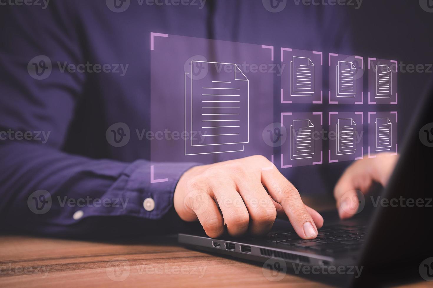 Document Management System, online documentation database and process automation to efficiently manage files. Corporate business technology. Employee man using a computer laptop in office. photo