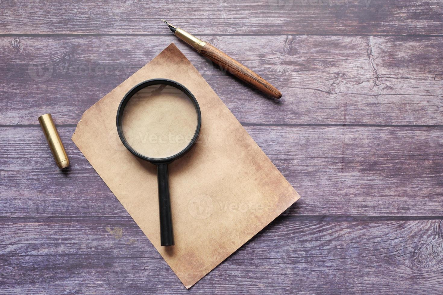 open book and magnifying glass on table. photo