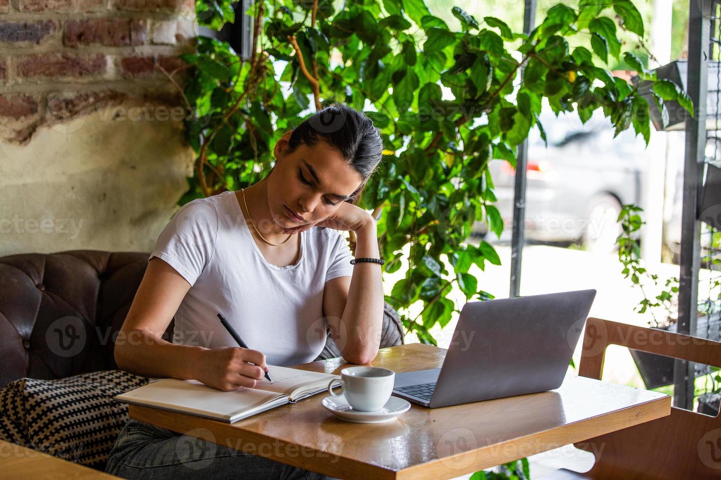 Young businesswoman is working in a cafeteria in her break.Woman taking a break. Enjoying work from coffee shop. Doing Business From coffee shop photo