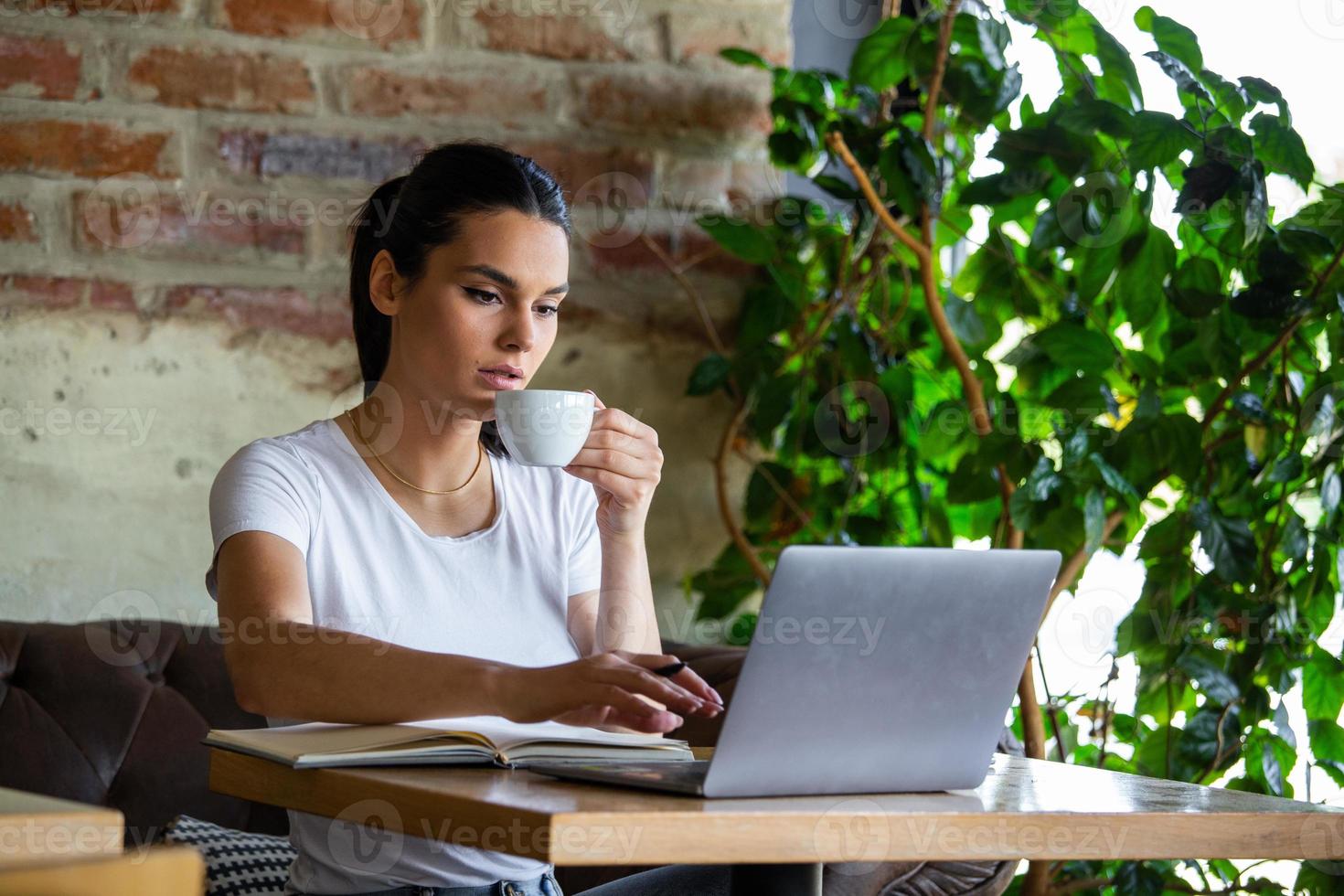 joven empresaria está trabajando en una cafetería en su descanso. mujer tomando un descanso. disfrutando del trabajo de la cafetería. hacer negocios desde la cafetería foto