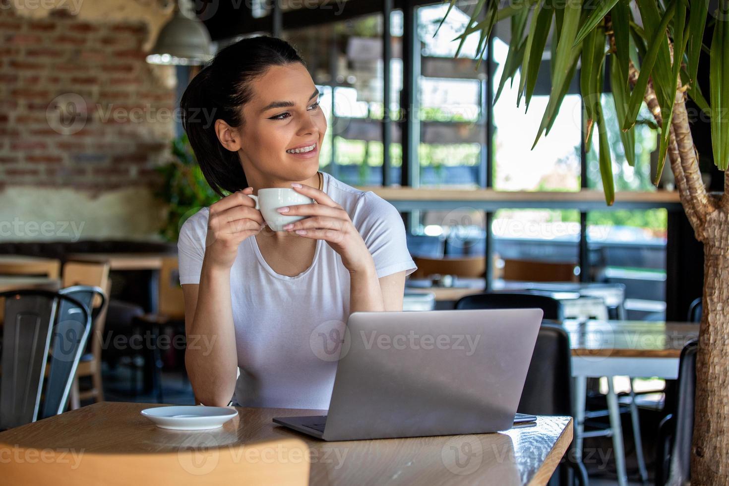 Young businesswoman is working in a cafeteria in her break.Woman taking a break. Enjoying work from coffee shop. Doing Business From coffee shop photo