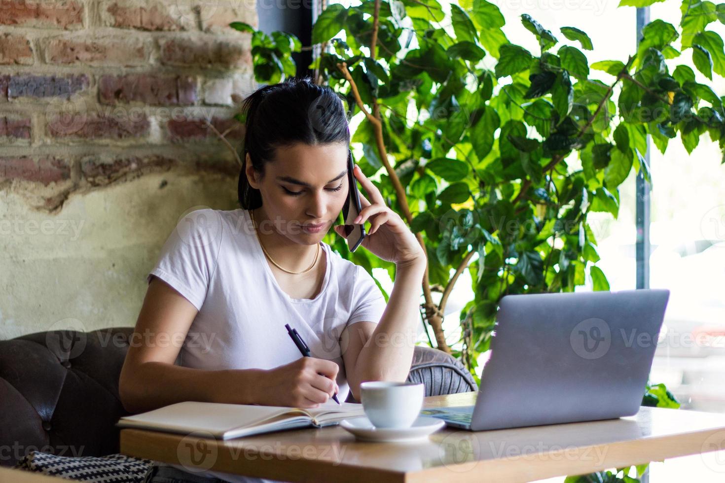 joven empresaria está trabajando en una cafetería en su descanso. mujer tomando un descanso. disfrutando del trabajo de la cafetería. hacer negocios desde la cafetería foto