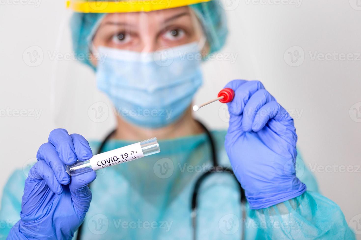 doctora caucásica sosteniendo un bastoncillo de recolección de hisopos, hisopado de muestras nasales y orales, cita para el procedimiento de prueba de pcr del paciente, crisis pandémica global de coronavirus covid-19 foto