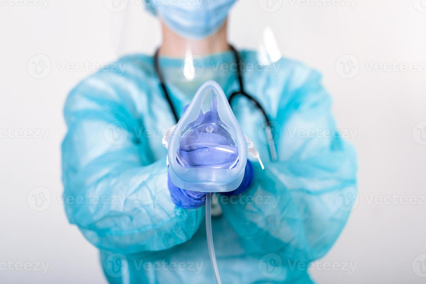 Doctor holding up oxygen mask as if to put on patient in hospital, Healthcare workers in the Coronavirus Covid19 pandemic in protective equipment put on oxygen mask patient diagnosis of coronavirus photo