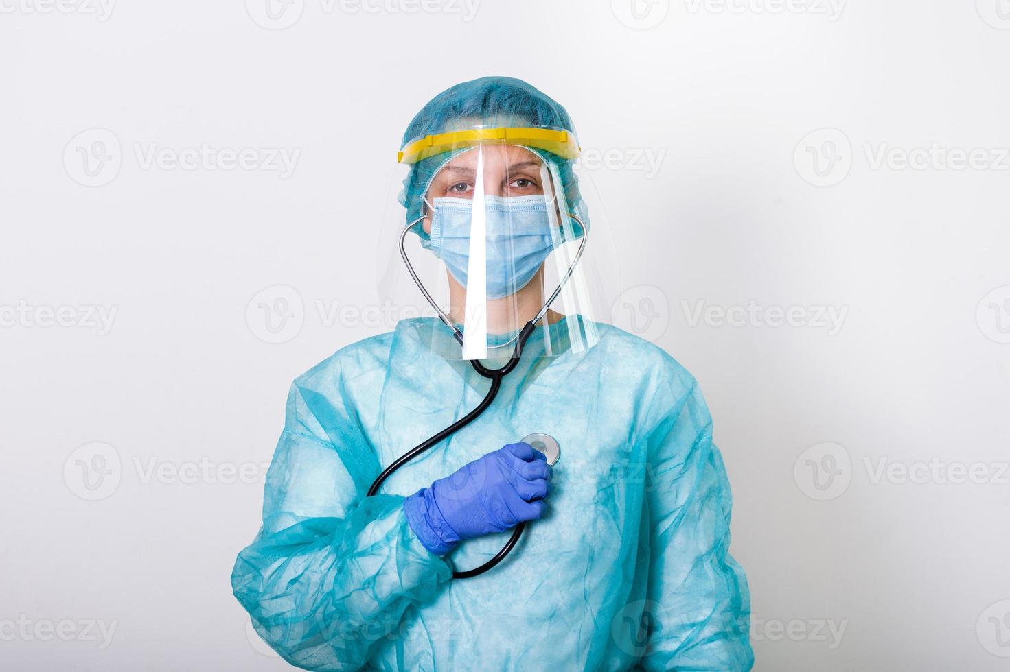 female doctor wearing PPE protection suite for fighting and stop Spread of Covid-19 coronavirus with white background and covid-19 outbreak concept. Medical worker in protective gear with stethoscope photo