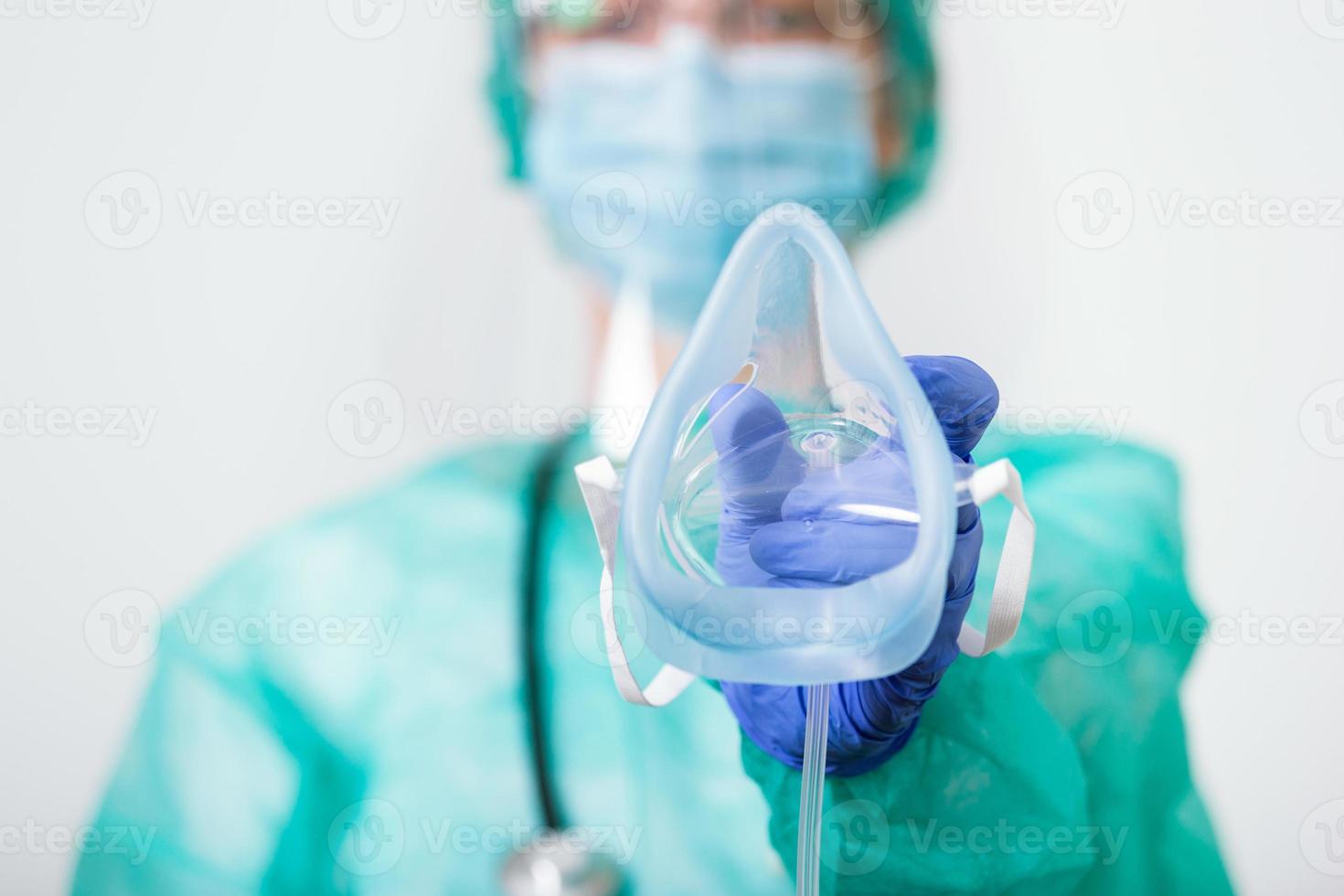 Doctor Woman holds Oxygen Mask for Inhale breath problem Patient, Coronavirus or Covid-19 attack Lungs. Healthcare worker in protective equipment put on oxygen mask patient diagnosis of coronavirus photo