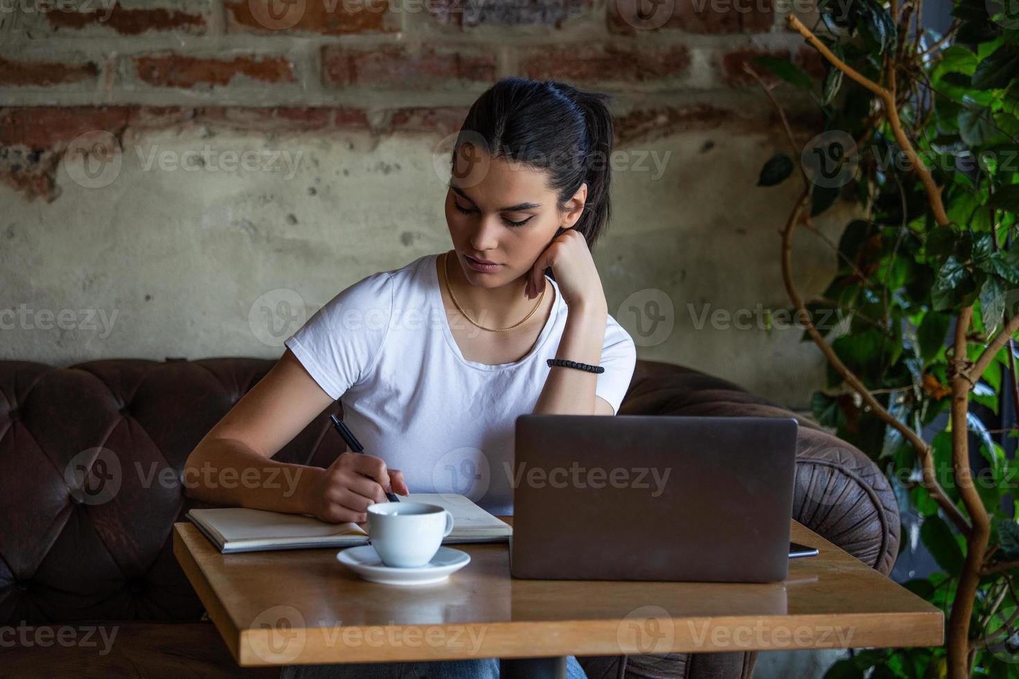 Young businesswoman is working in a cafeteria in her break.Woman taking a break. Enjoying work from coffee shop. Doing Business From coffee shop photo