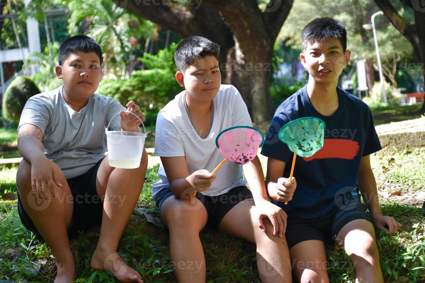 Three middle school boys in Southeast Asia hold devices to study and explore the ecology of the underwaters they live in. Ideas for Learning Outside the Classroom, soft and selective focus. photo