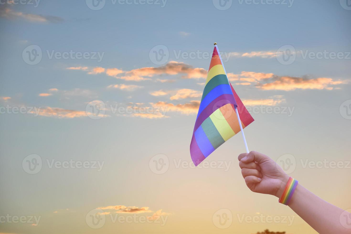 Rainbow flags, LGBT symbol, holding in hands, concept for LGBT community celebration in pride month, June, 2023, around the world. photo