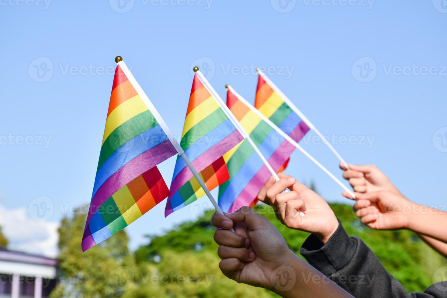 banderas del arco iris, símbolo lgbt, tomados de la mano, concepto para la celebración de la comunidad lgbt en el mes del orgullo, junio de 2023, en todo el mundo. foto