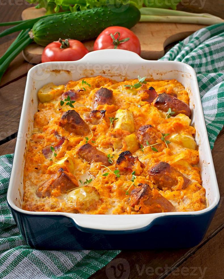 Casserole with sausage, bacon and apples in a pumpkin-cheese sauce photo