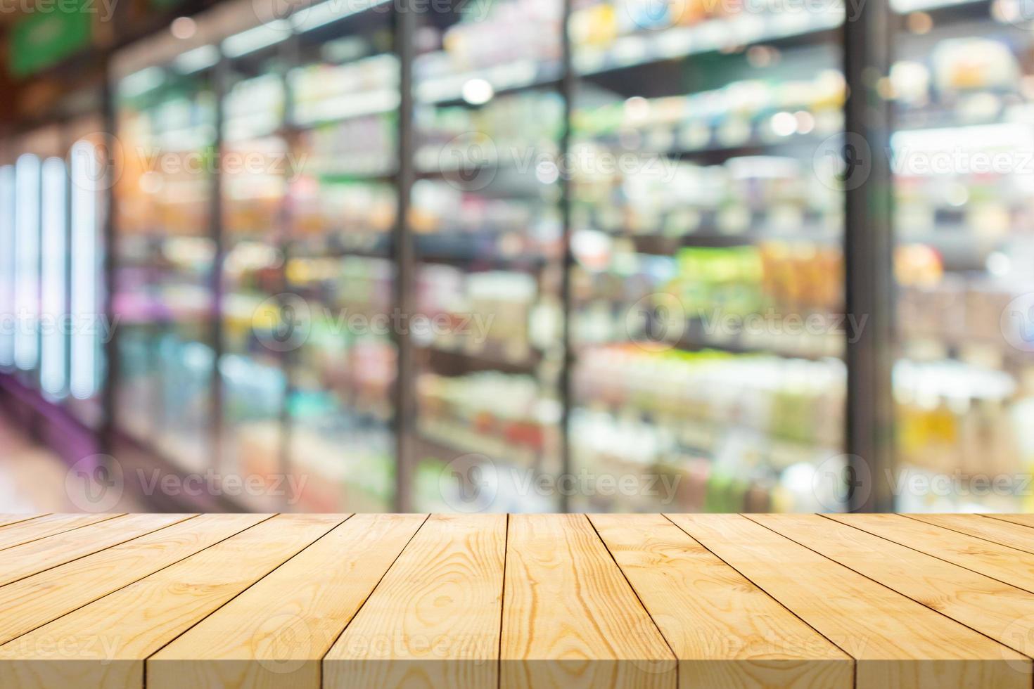 Empty wood table top with supermarket grocery store aisle and shelves blurred background photo