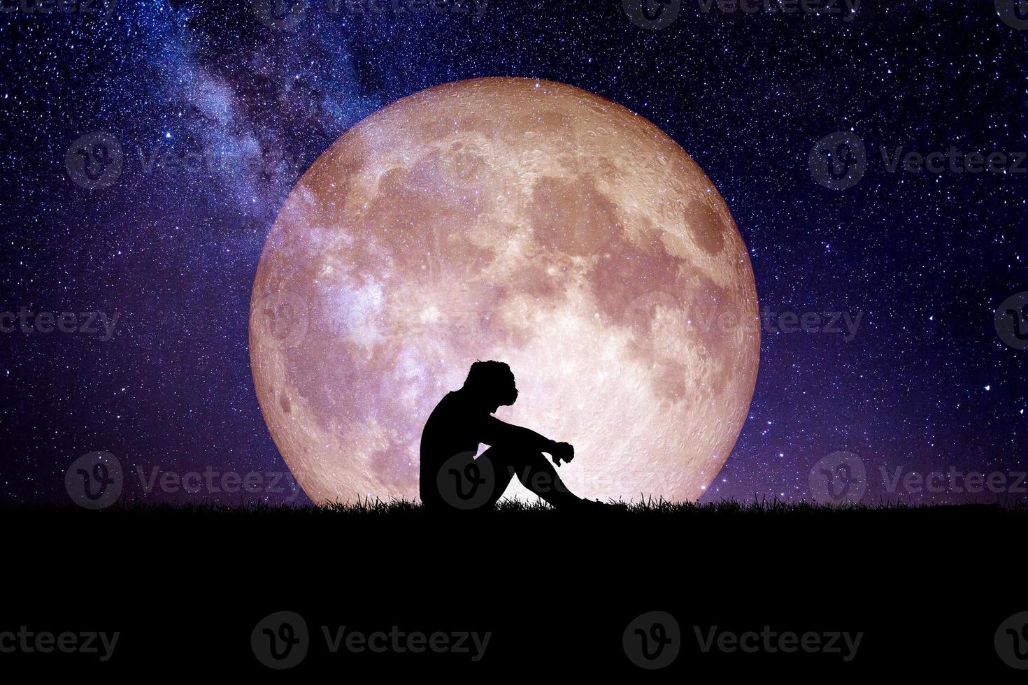 Desperate and lonely man in the background of the moon at night. Desperate, heartbreaking, and lonely concepts photo