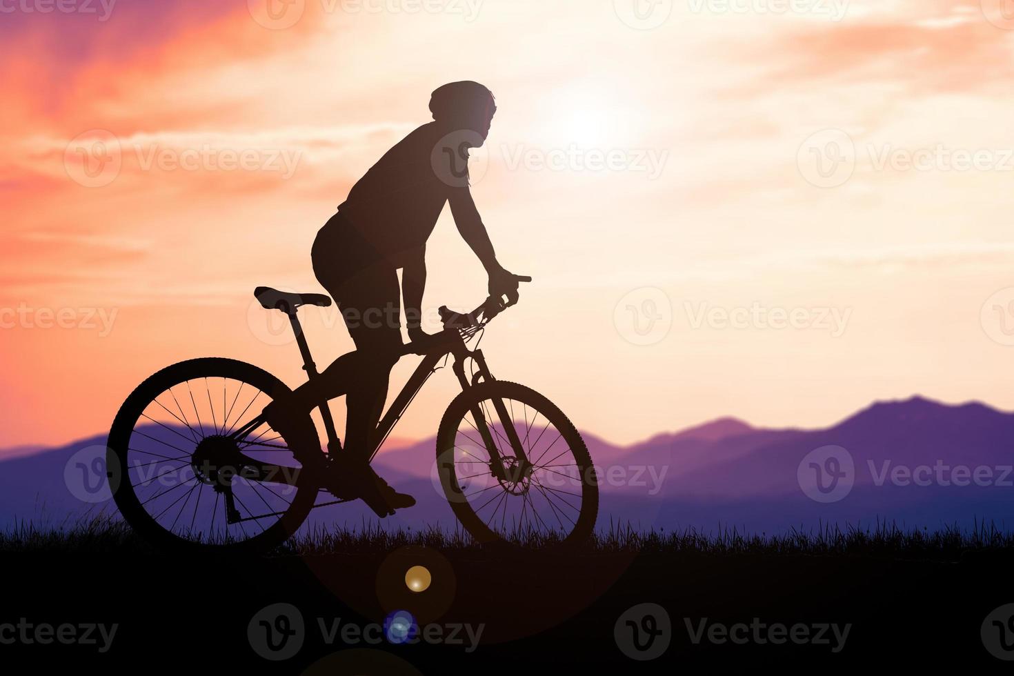 siluetas de bicicletas de montaña y ciclistas por la noche felizmente. concepto de viaje y fitness. silueta de ciclistas recorriendo el concepto de cicloturismo vespertino foto