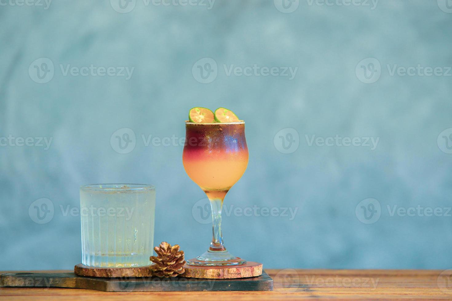 bebida refrescante café y zumo de naranja en la misma taza. café mezclado con jugo de naranja con hielo para enfriar en un hermoso vaso. foto