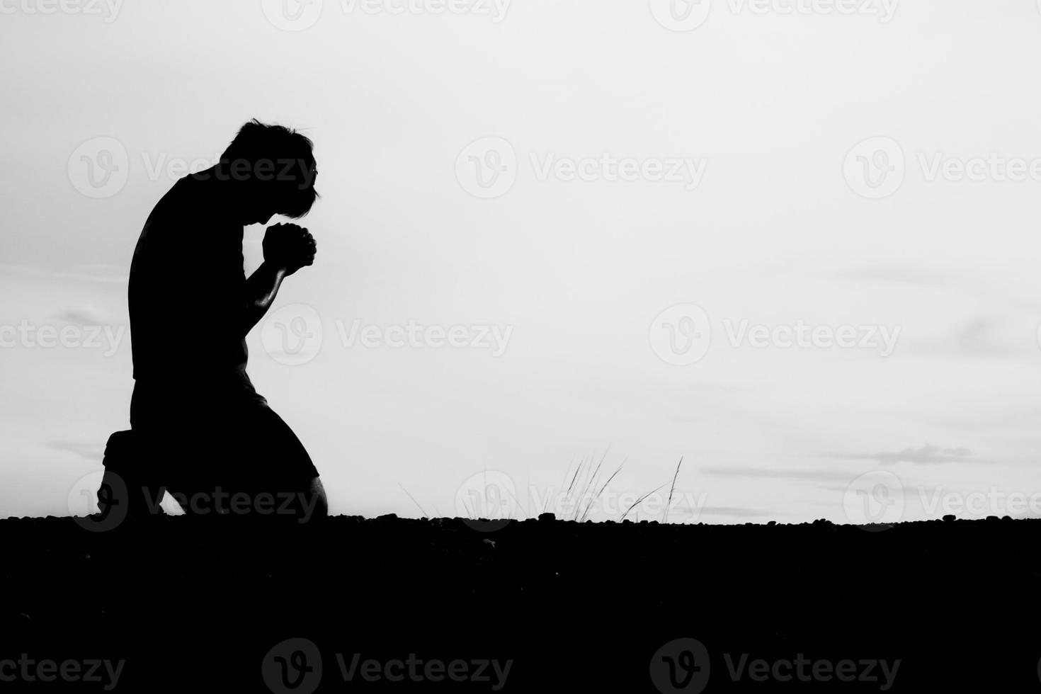 siluetas de hombres sentados y rezando por bendiciones. concepto de esperanza foto